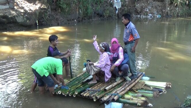 
Jembatan Hanyut, Warga Beraktivitas Gunakan Rakit Pohon Pisang